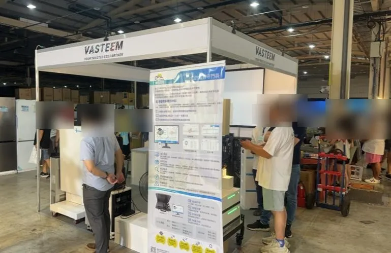 2025 台中家電展現場,鋒岳潔能的能源管理系統展板與家用儲能設備,民眾駐足參觀(臉部已模糊)